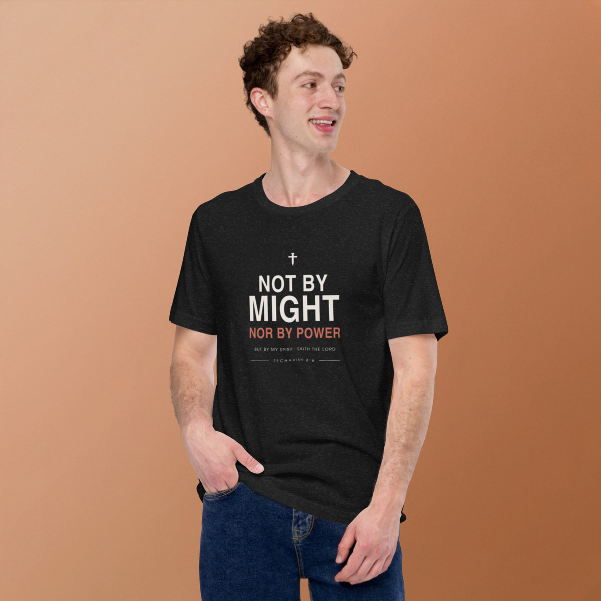 Not By Might T-Shirt — model wearing the black heather tee, front view on a warm backdrop